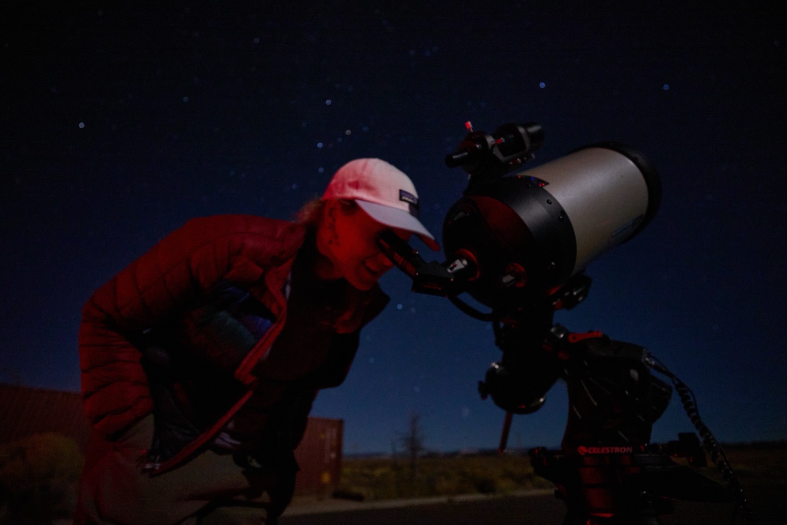 A tour guest looking through a Celestron telescope eyepiece under the stars near Bryce Canyon